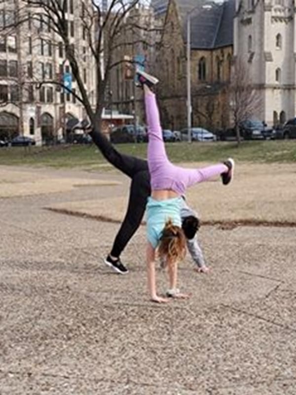 Amy, a former patient of Dr. Jay Granzow, MD, does a cartwheel in the park with her daughter.